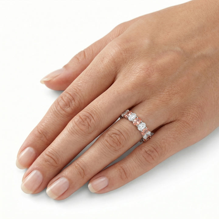 18K yellow gold oval cut eternity ring with alternating diamond and Padparadscha sapphires on ring finger