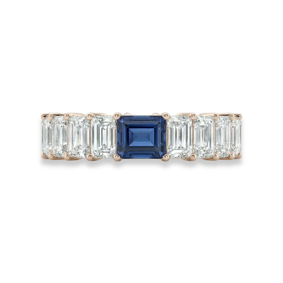 18K rose gold emerald cut eternity ring with blue sapphire center stone