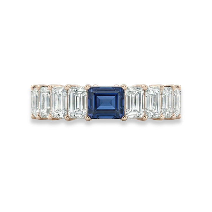 18K rose gold emerald cut eternity ring with blue sapphire center stone