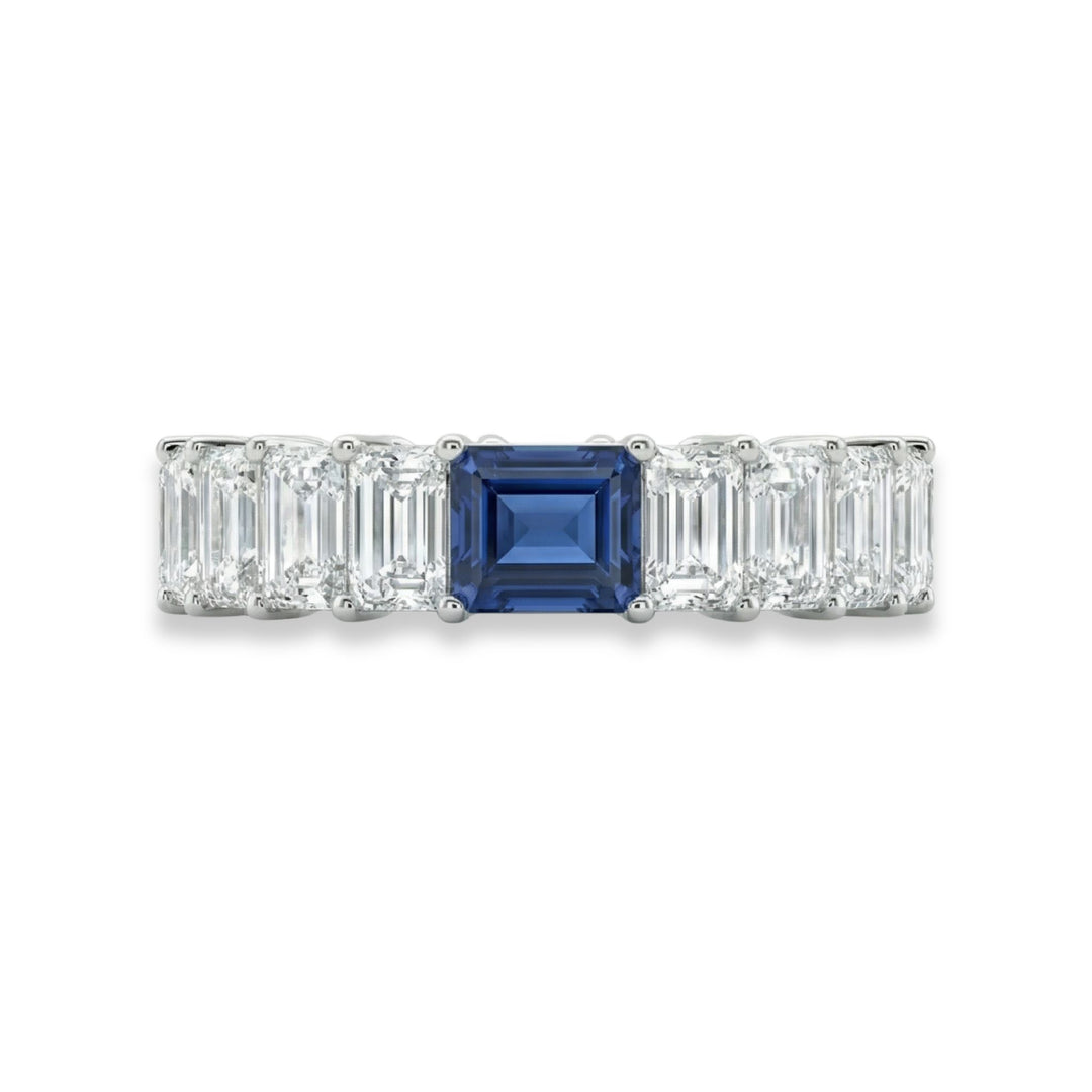 Platinum emerald cut eternity ring with blue sapphire center stone