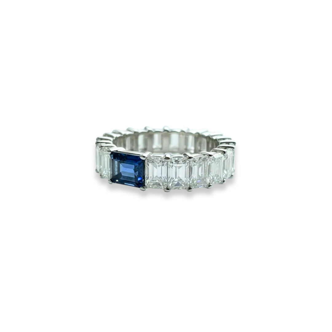 Platinum emerald cut eternity ring with blue sapphire center stone